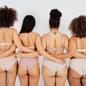 Four women in underwear standing arm-in-arm, showing inclusive sizing and fit for diverse body types.