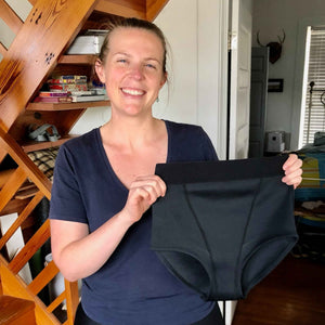 Our founder Lauren Fleming holding the first prototype of the Hem Support Wear high waisted garment.